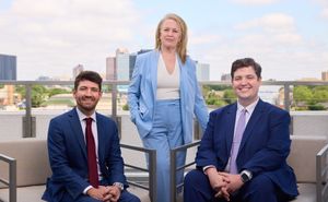 A group portrait of the three lawyers on a rooftop deck in front of the North Dallas skyline.