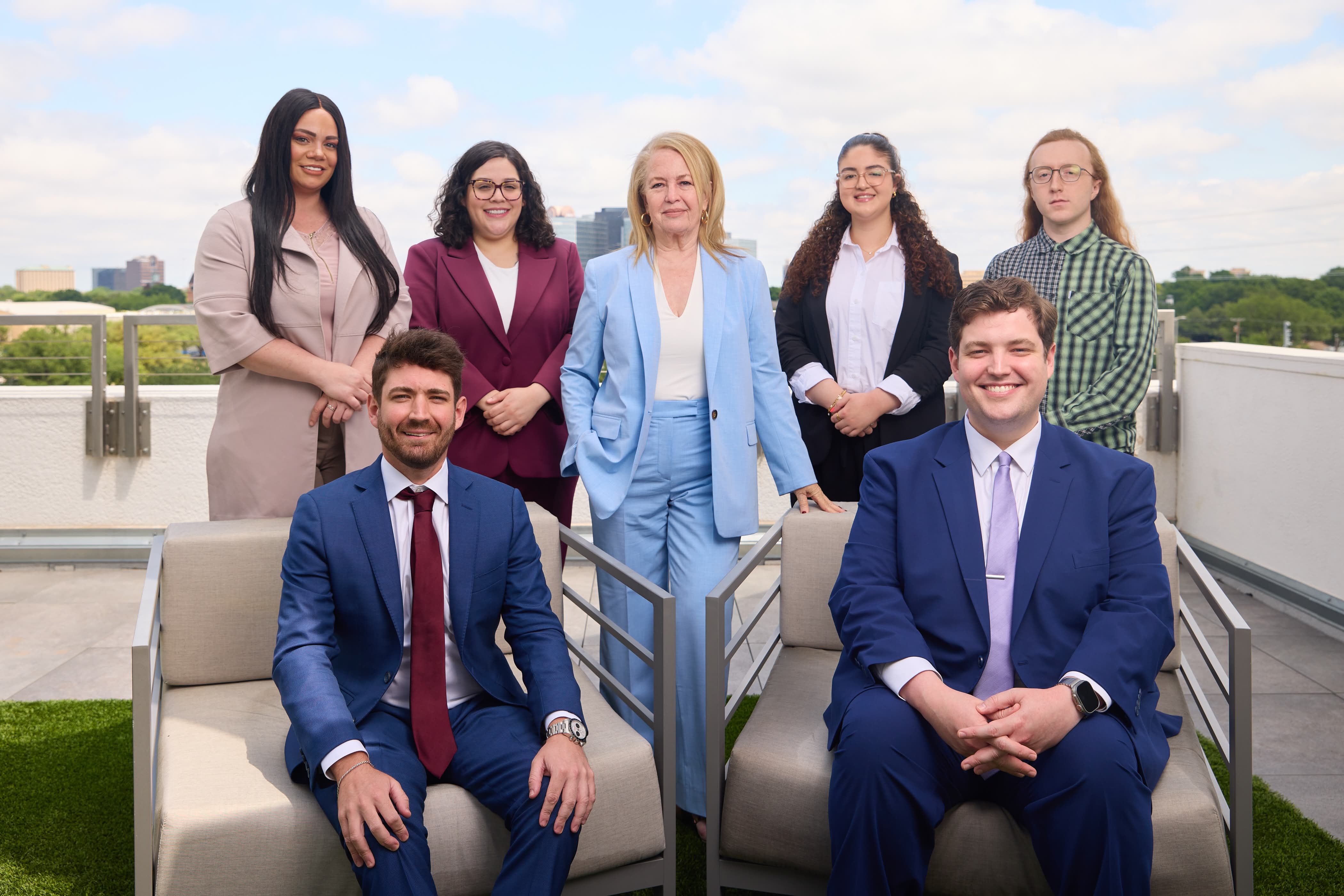 A group portrait of the three lawyers and several staff members on a rooftop.